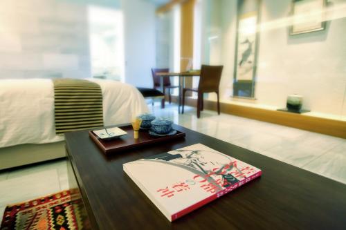 a room with a bed and a table with a book at Luxury Condo Shikine An Gion Shirakawa in Kyoto