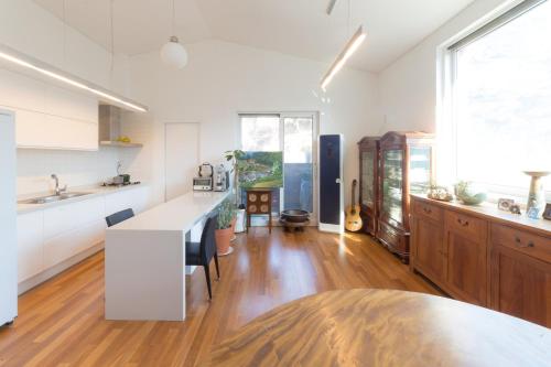 a kitchen with white cabinets and a wooden floor at Guesthouse The Kims in Seoul