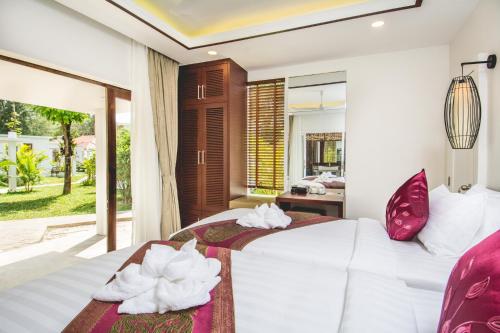 a bedroom with a white bed with towels on it at Sahaa Beach Resort in Sihanoukville