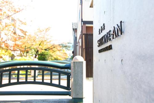 a bench next to a building with a sign on it at Luxury Condo Shikine An Gion Shirakawa in Kyoto