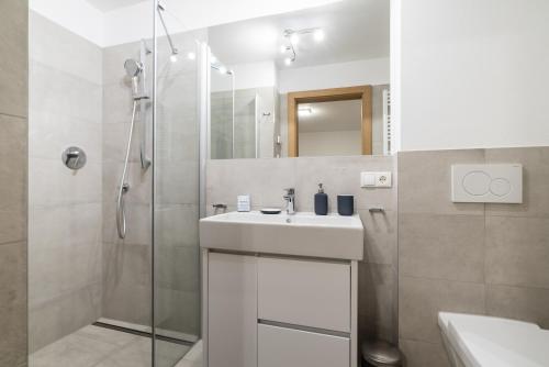a white bathroom with a sink and a shower at Fischis Alpen Appartements in Flachau