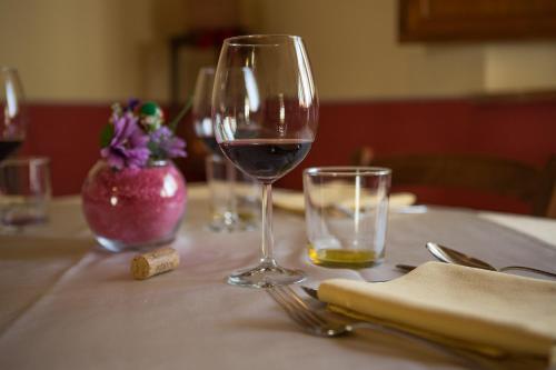 a glass of red wine sitting on a table at Agriturismo Borghetto Il Montino in Rapolano Terme