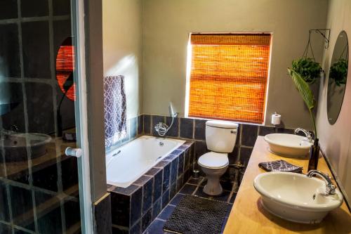 La salle de bains est pourvue d'une baignoire, de toilettes et d'un lavabo. dans l'établissement 368 on Vaal | Riverside Retreat, à Parys