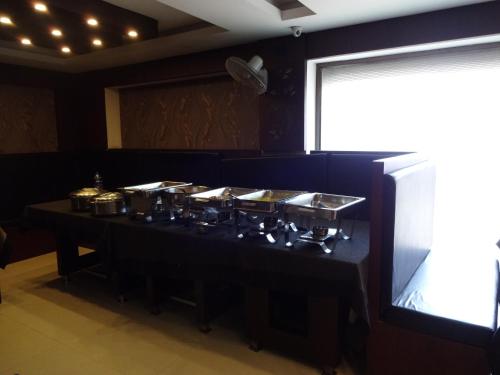 una camera con tavolo con pentole e padelle di Hotel A J Park a Alleppey