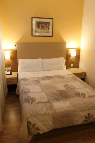 a bedroom with a large bed with two lamps on both sides at Hotel Mirador Puerta del Sol in Madrid