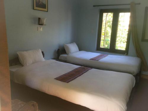 2 letti in una camera con finestra di Yeti Guest House a Pokhara