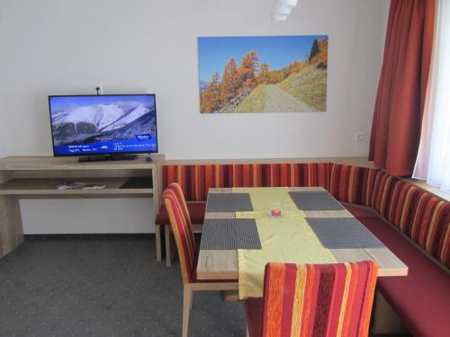 a dining room with a table and a television at Appartements Kroner in Nauders