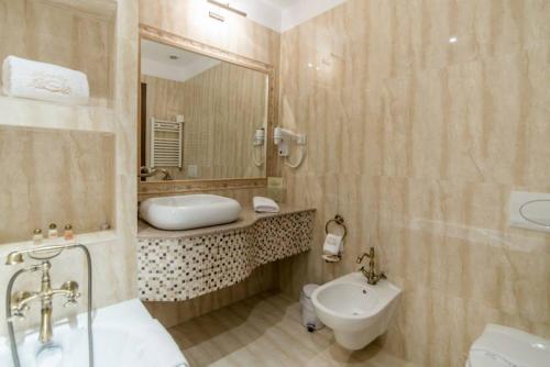 uma casa de banho com um lavatório, um WC e um espelho. em Anette Resort & SPA em Covaci