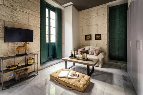 a living room with green doors and a couch at Luces de Catedral in Alicante