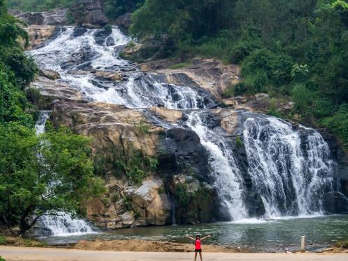 a person standing in front of a waterfall at VuLinh Family -Homestay in Yên Bình