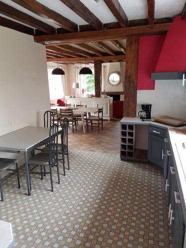 une cuisine et une salle à manger avec tables et chaises dans l'établissement Gite le Courbat, à Le Liège