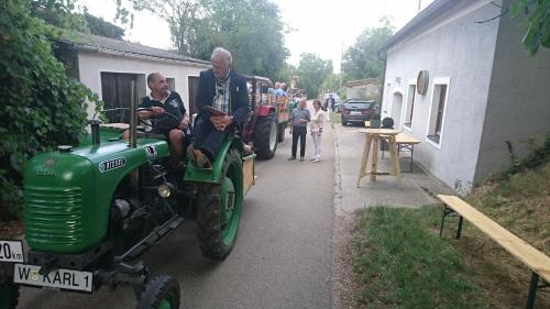 a man and a child sitting on a green tractor at Weingut Familie Bauer in Großriedenthal