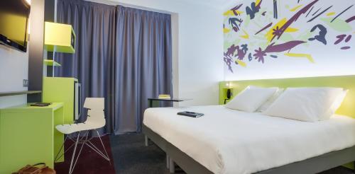 a hotel room with a large bed and a desk at ibis Styles Nantes Centre Gare in Nantes