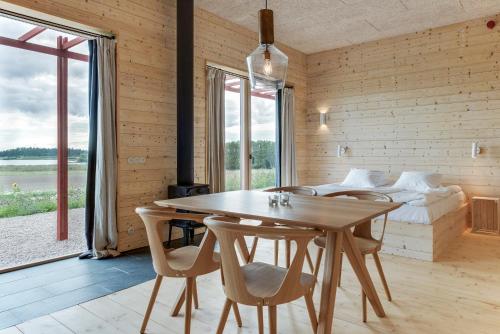 Lindeborgs Eco Retreat في Vrena: غرفة خشبية مع طاولة وكراسي وسرير