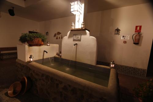 a room with a large bath tub in a room with lights at Hotel Rural Arroyo la Plata by Bossh Hotels in Jerez de los Caballeros