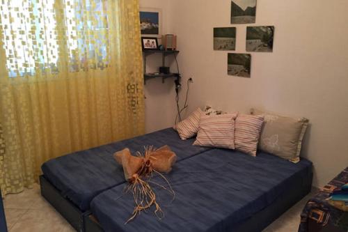 a bedroom with a bed with blue sheets and a yellow curtain at Isabelle's apartment in Kallithea Halkidikis