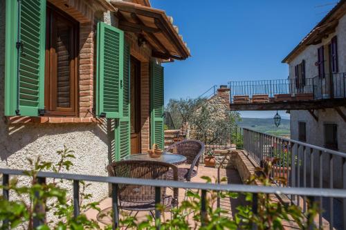 a patio with a table and chairs on a balcony at Agriturismo Borghetto Il Montino in Rapolano Terme