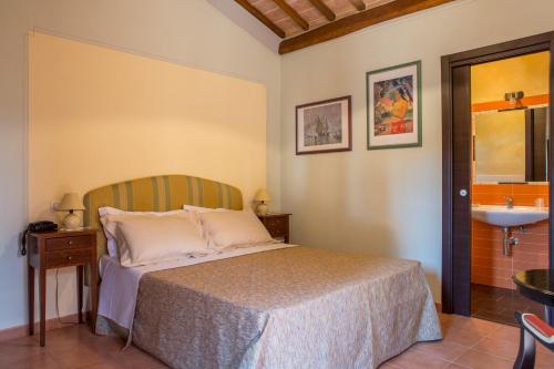 a bedroom with a bed and a sink at Agriturismo Borghetto Il Montino in Rapolano Terme