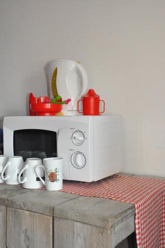 a microwave sitting on top of a table with mugs at Hotel Aan Zee in De Panne