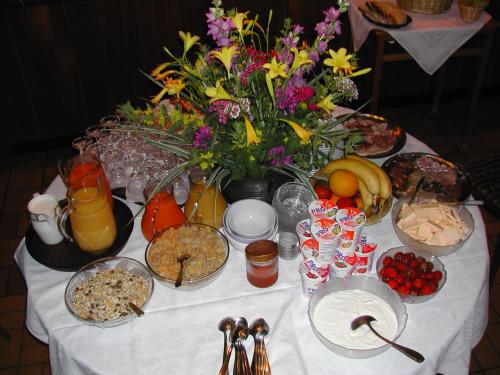 a table topped with plates of food and flowers at Gasthaus-Pension Zum Kreuz in Stühlingen