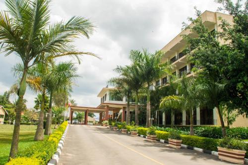 une route devant un bâtiment planté de palmiers dans l'établissement Lake View Resort Hotel, à Mbarara