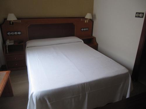 a small bedroom with a white bed in a room at Don Juan in Granada