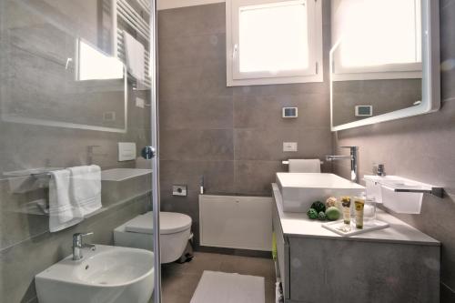 a bathroom with a sink and a toilet and a mirror at Relais Villa Clodia in Lazise