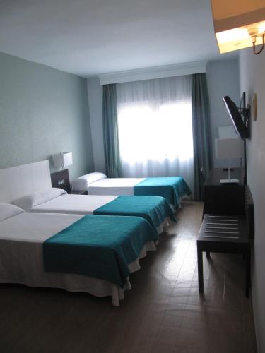 a row of beds in a hotel room at Don Juan in Granada