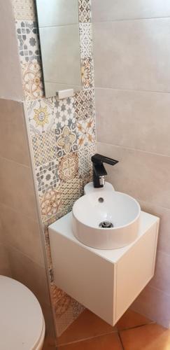 bagno con lavandino bianco e servizi igienici di L'Homme Tranquille a Salerno