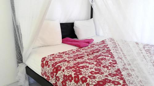Una cama con una manta roja y blanca. en Mirissa Harbour View, en Mirissa