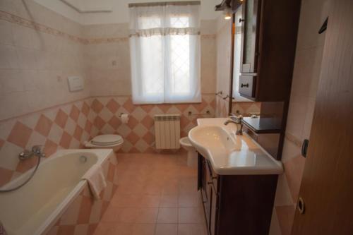 ein Badezimmer mit einer Badewanne, einem Waschbecken und einem WC in der Unterkunft Paoline's suite in villa in Fiumicino
