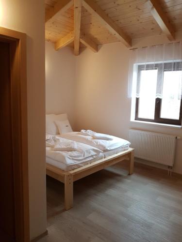 a bedroom with a bed in a room with a window at Rodinný wellness hotel U Langrů in Dolní Věstonice
