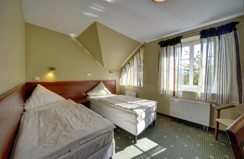 a bedroom with two beds and a window at Hotel Belweder - przy hotelu Golebiewski in Karpacz