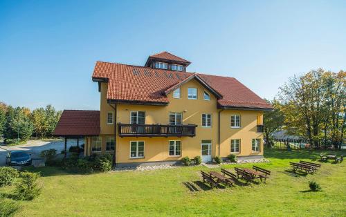 ein großes gelbes Haus mit rotem Dach in der Unterkunft Hotel Belweder - przy hotelu Golebiewski in Karpacz