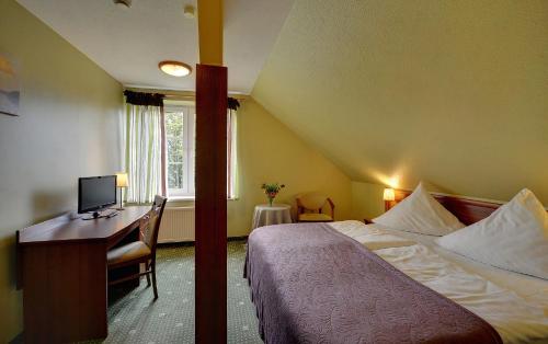 a hotel room with a bed and a desk with a computer at Hotel Belweder - przy hotelu Golebiewski in Karpacz