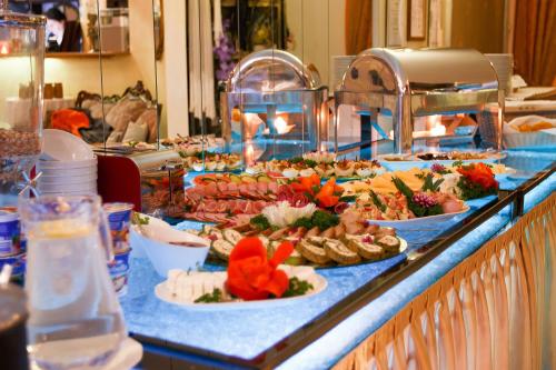 a buffet with many plates of food on a table at Dworek Dębówko in Bartoszyce