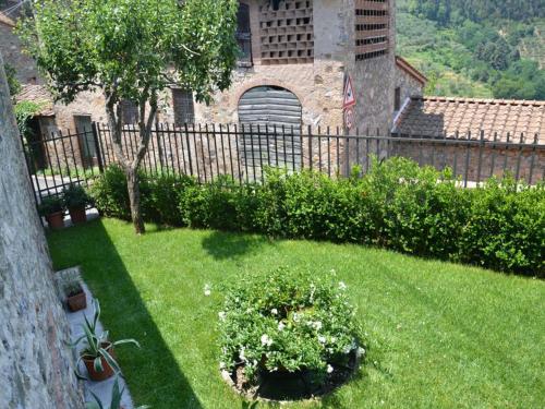 a yard with a fence and some plants and flowers at Capannori Stylish Townhouse in Castelvecchio