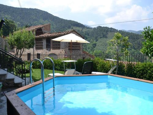 a swimming pool in front of a house at Capannori Stylish Townhouse in Castelvecchio