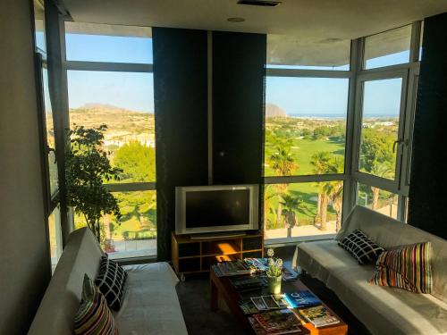a living room with a television and large windows at 01 Loft Alenda Golf in Monforte del Cid