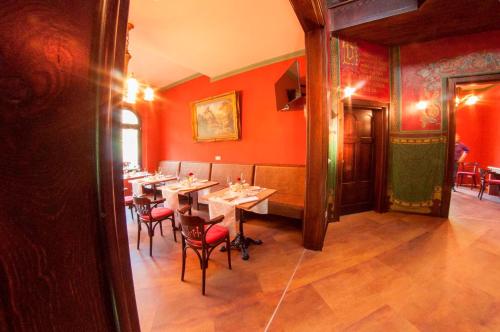 a restaurant with red walls and tables and chairs at Pension VILLA KLEINE WARTBURG in Eisenach