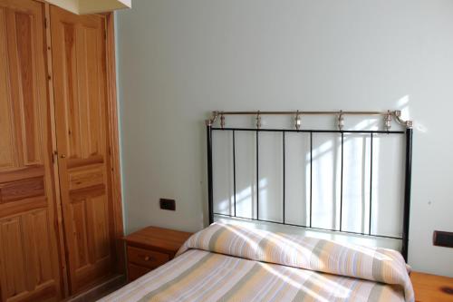 1 cama con cabecero de metal en un dormitorio en ATRA, en Santa Cruz de Moya