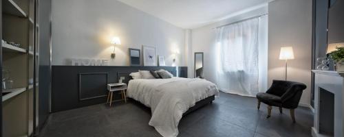 - une chambre avec un grand lit et une chaise dans l'établissement Suite Vogue Visconti, à Voghera