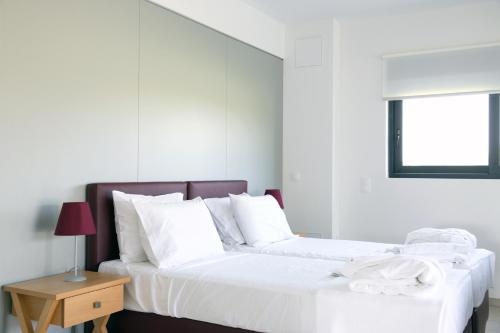 キパリシアにあるGeo Boutique Villaの白いベッドルーム(ベッド2台、テーブル付)