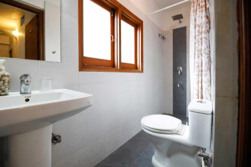 łazienka z toaletą, umywalką i oknem w obiekcie Silver Moon Haveli w mieście Udaipur