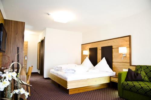 a hotel room with a bed and a couch at Hotel Garni Arosa in Ischgl