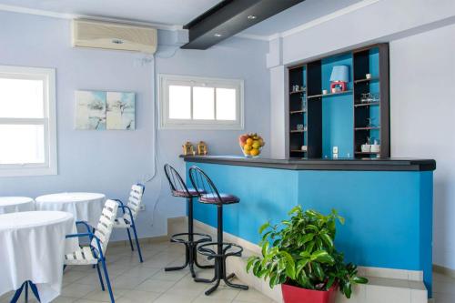 un restaurante azul con sillas y un bar en Hotel Mariona en Pythagoreio
