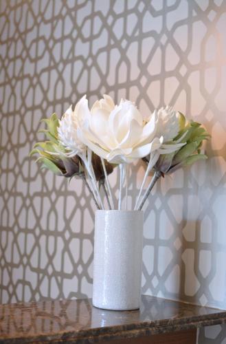a vase filled with white flowers sitting on a table at Regal Inn Hotel Midrand in Midrand