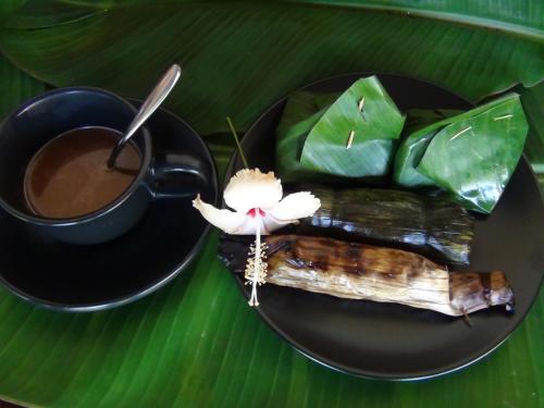 um prato com uma chávena de café e um pedaço de comida em Tuaprodhome em Khao Lak