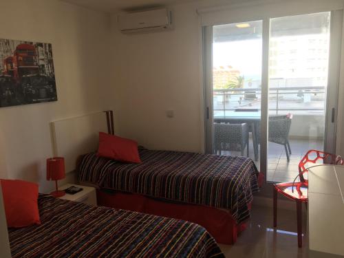 a hotel room with two beds and a balcony at Apartamento Forest 2 in Punta del Este