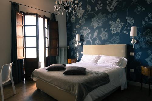 a bedroom with a bed with blue and white wallpaper at La Rocca Guest House & Spa in Montefalco